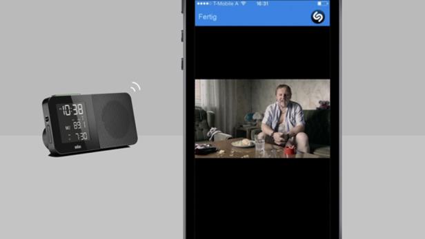 Ein digitales Radio wird per Smartphone mit einem Mann vor dem Fernseher verbunden.