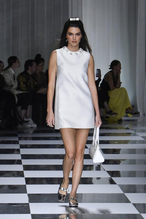 Kendall Jenner in einem weißen Kleid auf einem Laufsteg.