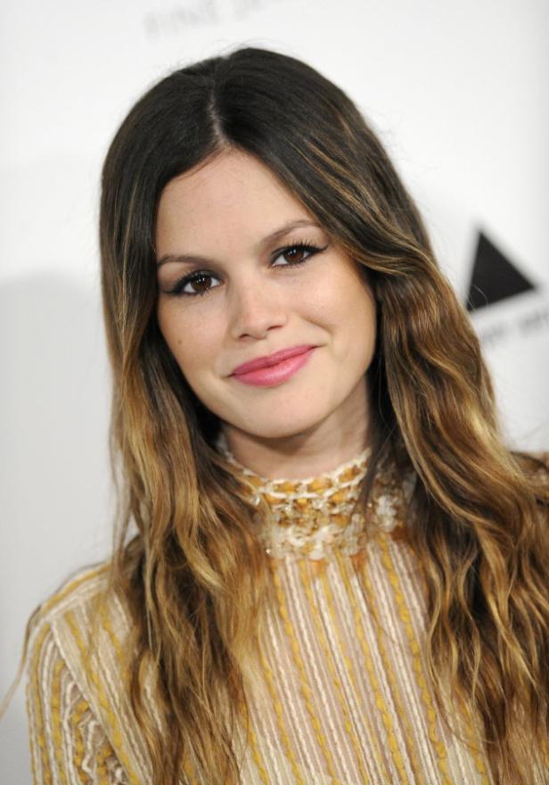 Ein Porträt von Rachel Bilson mit langen, gewellten Haaren und einem gemusterten Oberteil.