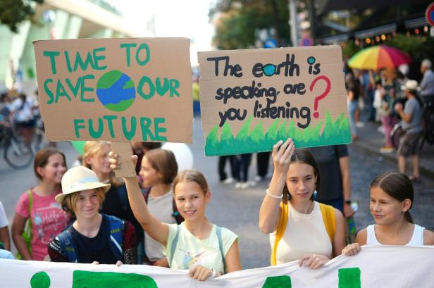 Eine Gruppe junger Menschen demonstriert mit Schildern für den Klimaschutz.