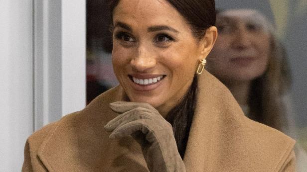 Meghan Markle mit beigem Mantel lächelt für die Kameras