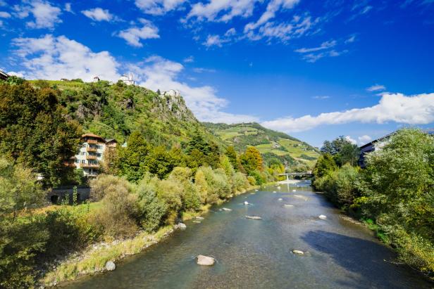 Der Eisack fließt bei Bozen durch eine grüne Landschaft.