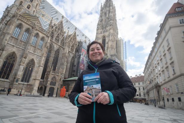 Eine Frau hält ein Buch mit dem Titel „Verbrecherisches Wien“ vor dem Stephansdom.