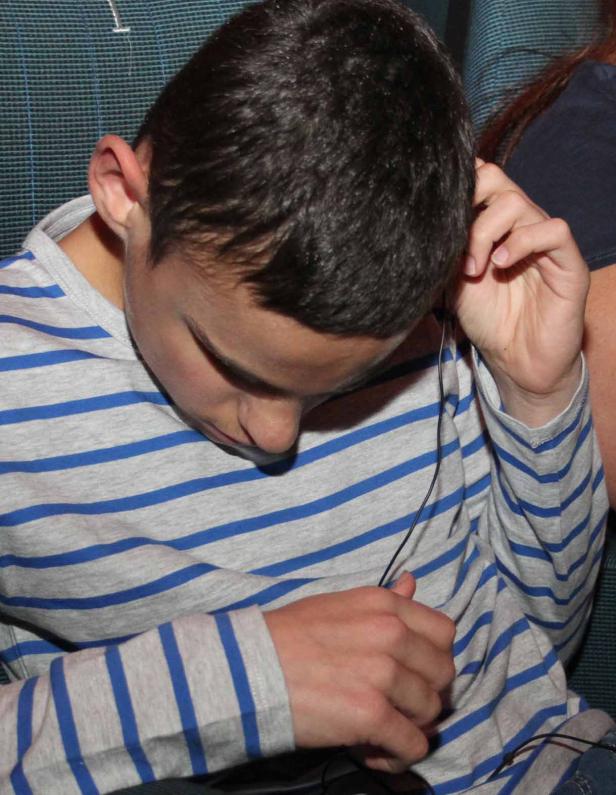 Ein junger Mann hört Musik über Kopfhörer.