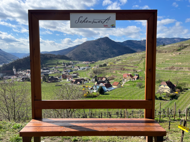 Blick durch einen Holzrahmen auf die Weinberge und das Dorf Spitz an der Donau.