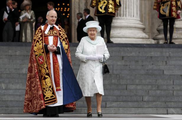 Königin Elisabeth II. in Begleitung eines Geistlichen auf den Stufen der St Paul's Kathedrale.