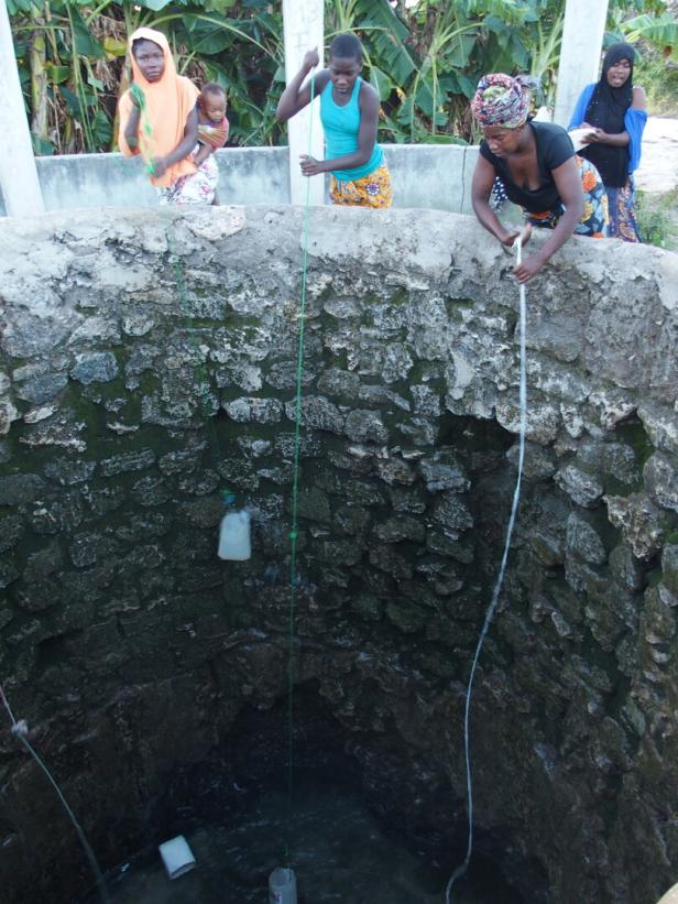 Vasco da Gama Brunnen in Mosambik, Frauen heben Wasser aus dem Brunnen