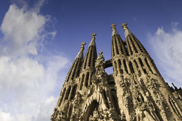 Die Sagrada Familia in Barcelona vor blauem Himmel mit Wolken.