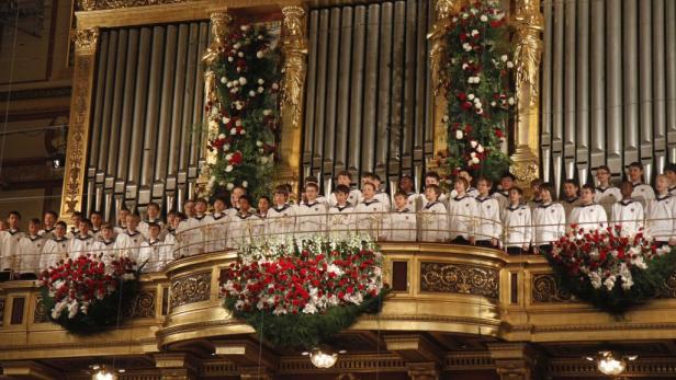 Die Wiener Sängerknaben stehen auf einer verzierten Empore vor einer Orgel.