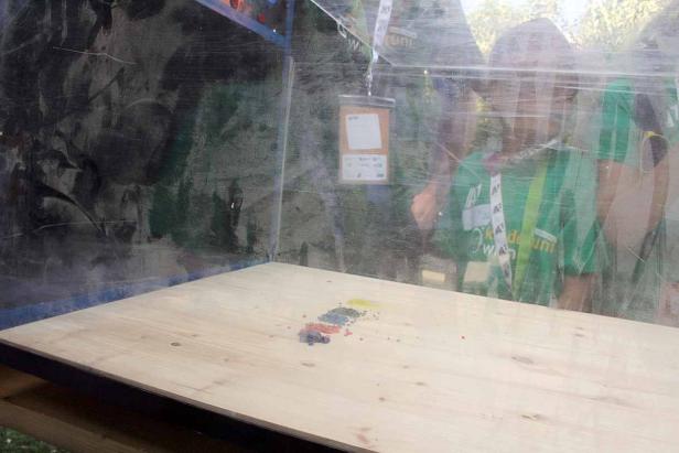 Ein Tisch mit Farbpigmenten in einem durchsichtigen Behälter.