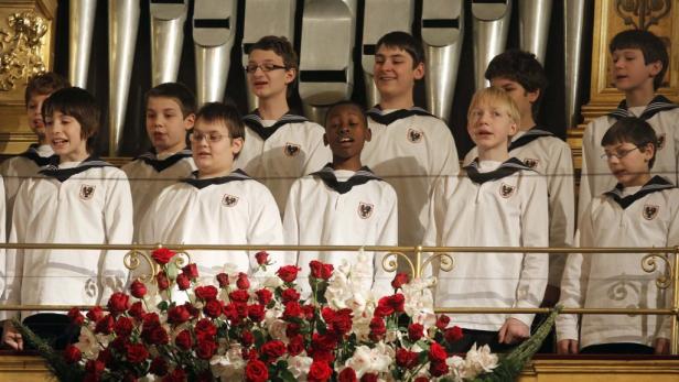Die Wiener Sängerknaben treten vor einer Orgel und roten Rosen auf.