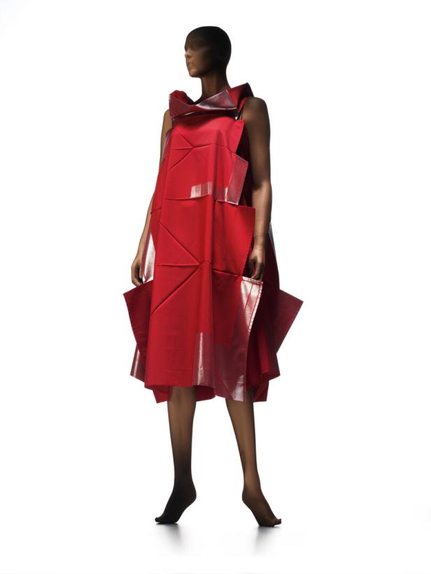 Eine Schaufensterpuppe trägt ein rotes, geometrisch geschnittenes Kleid mit silbernen Akzenten.