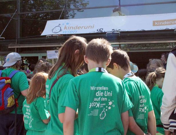 Kinder stehen vor der Kinderuni Wien und tragen grüne T-Shirts.