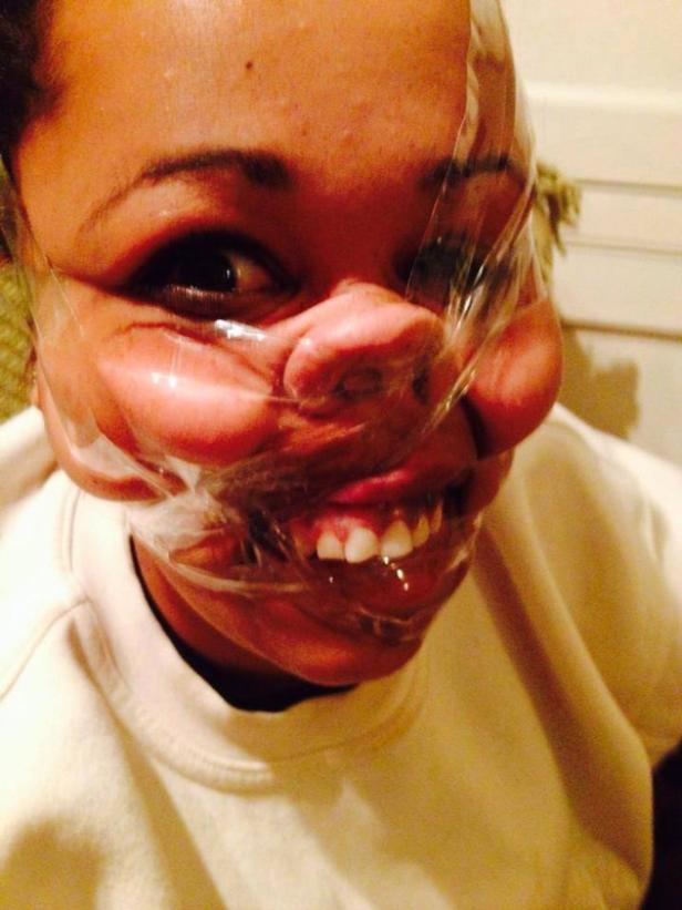 Eine Frau hat Frischhaltefolie um ihr Gesicht gewickelt.