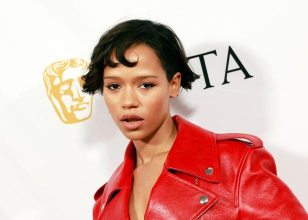 Eine Frau mit kurzem, dunklem Haar und roter Lederjacke vor einem BAFTA-Logo.