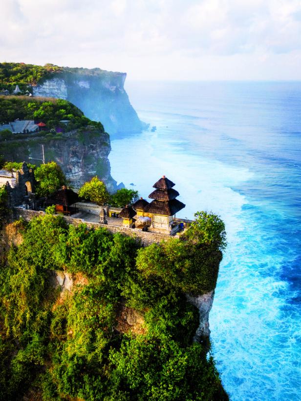 Ein Tempel thront auf einer Klippe mit Blick auf das blaue Meer.