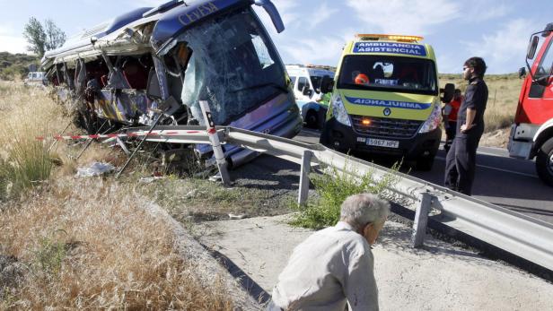 Ein schwer beschädigter Bus nach einem Unfall, mit Rettungskräften vor Ort.