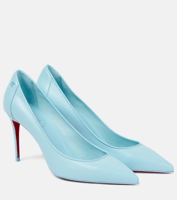 Ein Paar hellblaue High Heels mit roten Absätzen stehen vor einem weißen Hintergrund.
