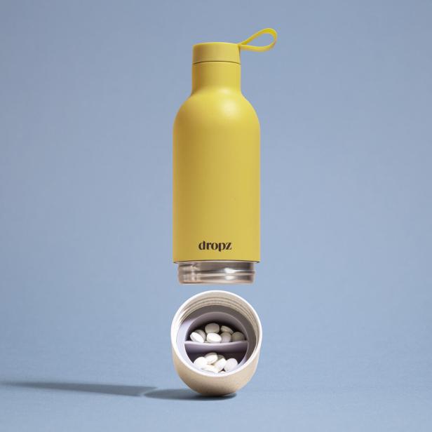 Eine gelbe „dropz“-Trinkflasche mit einem abnehmbaren Boden, der Pillen enthält.