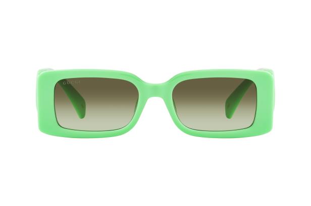 Eine hellgrüne Gucci-Sonnenbrille mit braun getönten Gläsern.