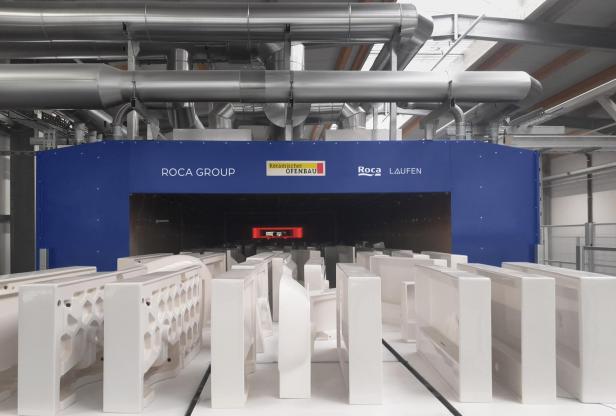 Keramische Sanitärobjekte vor einem Ofen der Roca Group.