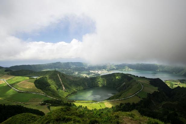Blick auf die grüne Landschaft und einen Kratersee auf den Azoren.