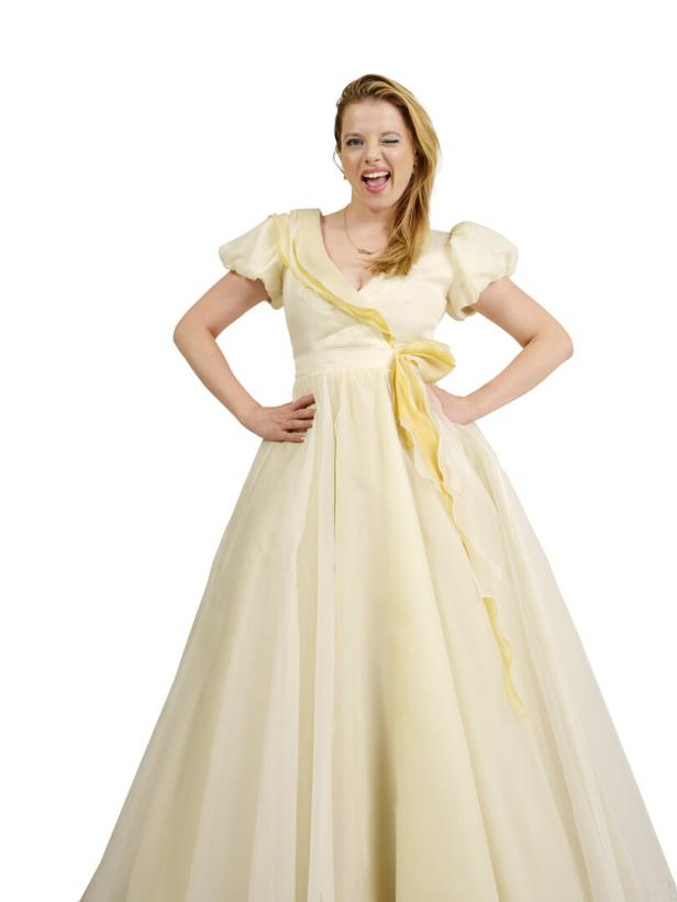 Jella Haase in einem hellgelben Ballkleid, zwinkernd in die Kamera.