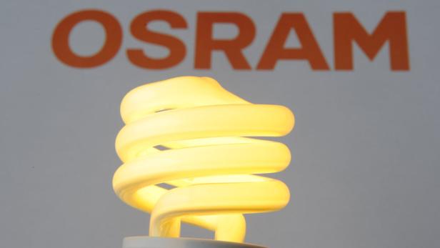 Eine leuchtende Energiesparlampe vor dem Osram-Logo.