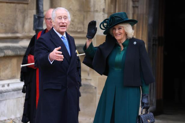 König Charles und Königin Camilla bei Ostermesse 2024: Charles in navy-farbenem Anzug mit hellblauer Krawatte, Camilla in grünem Kleid und schwarzem Cape