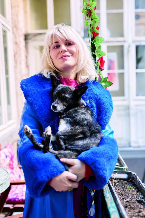 Regisseurin Jasmin Baumgartner hält einen kleinen Hund im Arm.