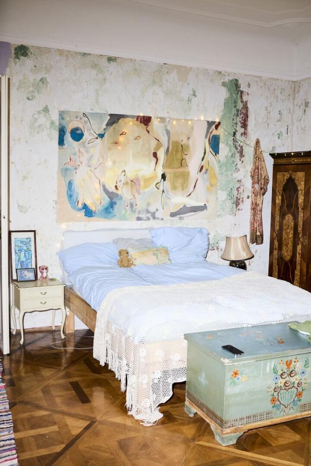 Ein Schlafzimmer mit einem Bett, einem Nachttisch und einem bemalten Schrank.
