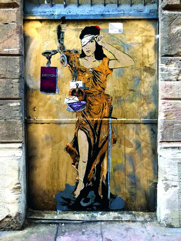 Ein Wandgemälde zeigt Justitia mit verbundenen Augen, die eine Waage und Dokumente hält.