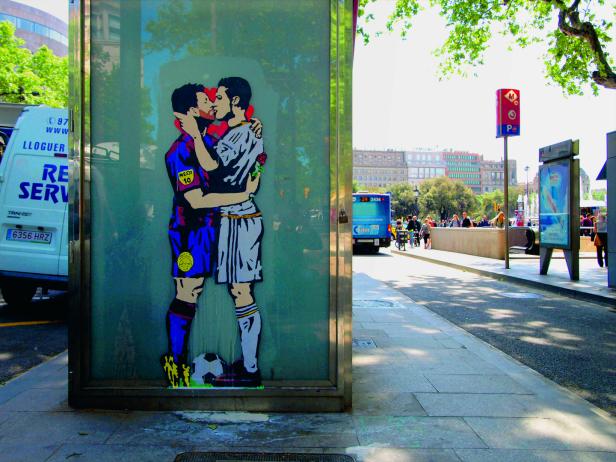 Ein Graffiti zeigt Lionel Messi und Cristiano Ronaldo, die sich umarmen und küssen.