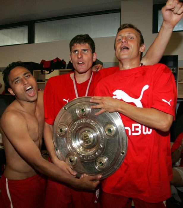 Drei Fußballspieler des VfB Stuttgart feiern mit der Meisterschale.