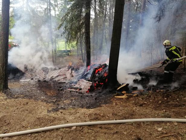 Brennender Holzstoß mitten im Wald beschäftigt die Polizei