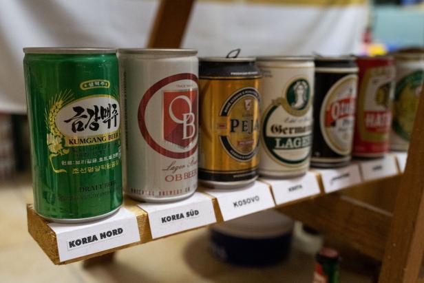 Eine Reihe von Bierdosen aus verschiedenen Ländern, darunter Nordkorea, Südkorea und Kosovo.