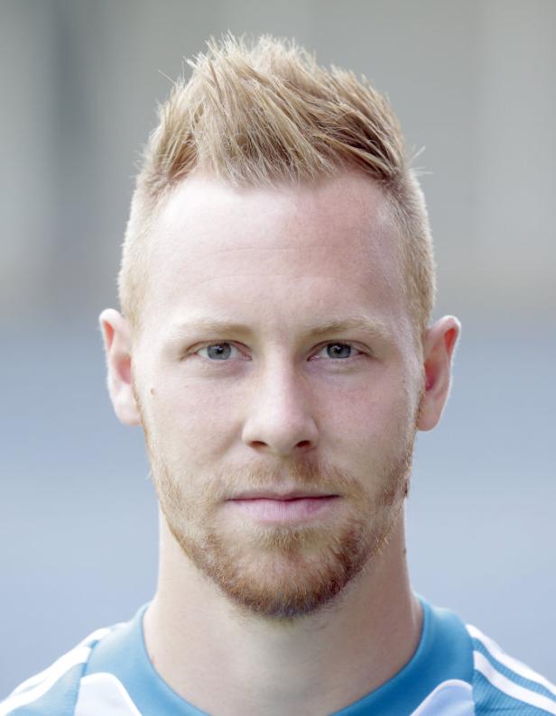 Porträt eines Mannes mit blonden Haaren und Bart.