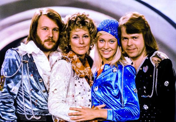 Die schwedische Popgruppe ABBA in extravaganten Kostümen posiert für ein Gruppenfoto.