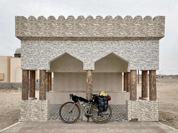 Ein Fahrrad steht vor einem verzierten Gebäude im Oman.