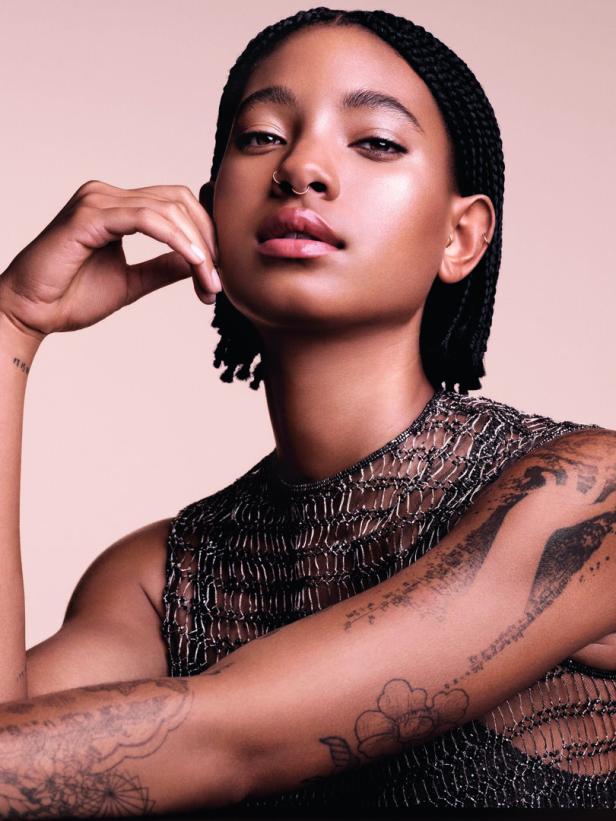 Willow Smith posiert mit geflochtenen Zöpfen, Nasenring und Tattoos auf ihren Armen.