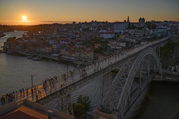 Sonnenuntergang auf der Ponte Dom Luis I aus der Vogelperspektive, Blick auf Porto und den Douro, viele Menschen stehen auf der Brücke