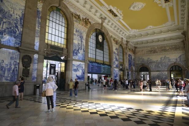 Bahnhof São Bento in Porto, blaue Fließen an den Wänden, helle Bahnhofshalle mit gelber Stuckdecke