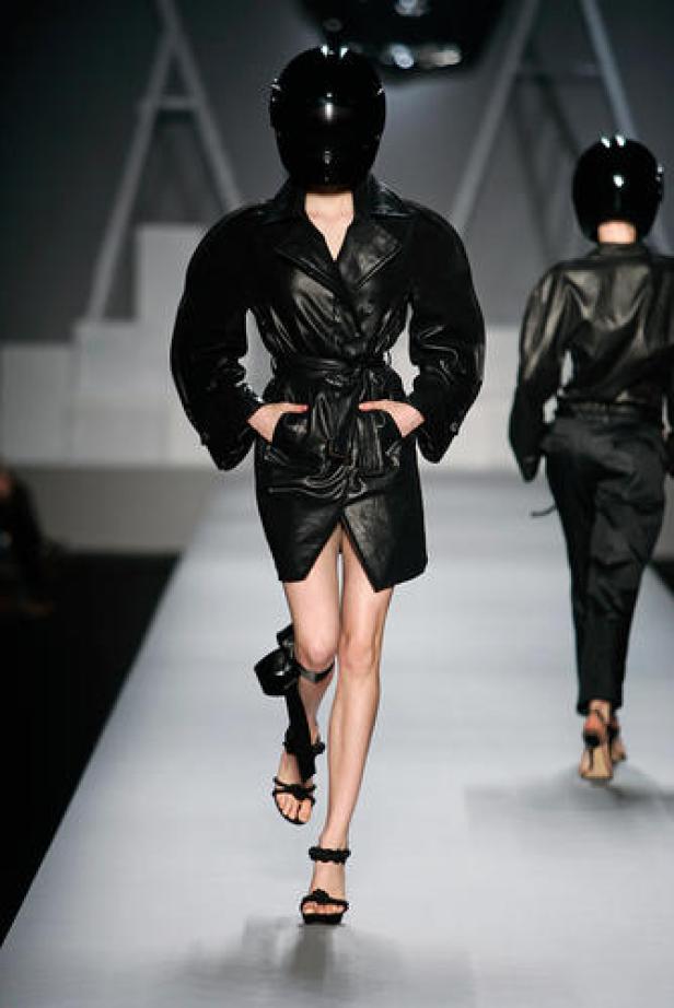 Models in schwarzen Helmen und Lederoutfits auf einem Laufsteg.