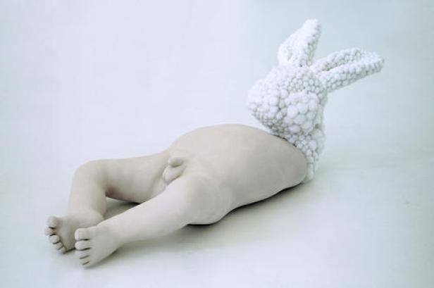 Eine Skulptur, die einen Babykörper mit einem Kopf aus Blumenkohl darstellt.