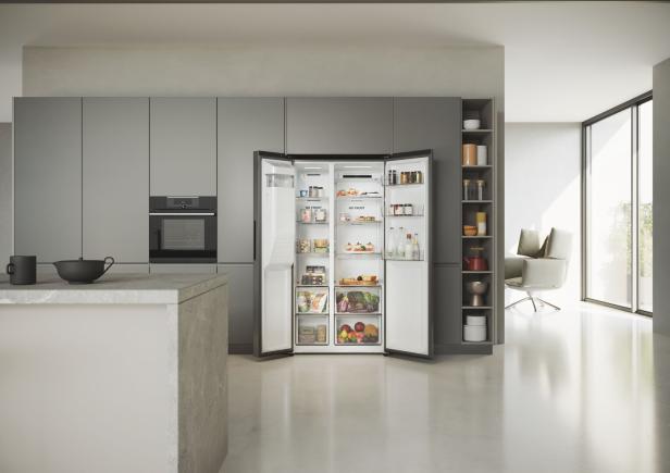 Ein offener, voll bestückter Side-by-Side-Kühlschrank in einer modernen Küche.