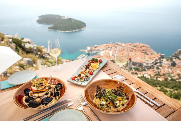 Ein Tisch mit Meeresfrüchtegerichten und Wein mit Blick auf Dubrovnik.