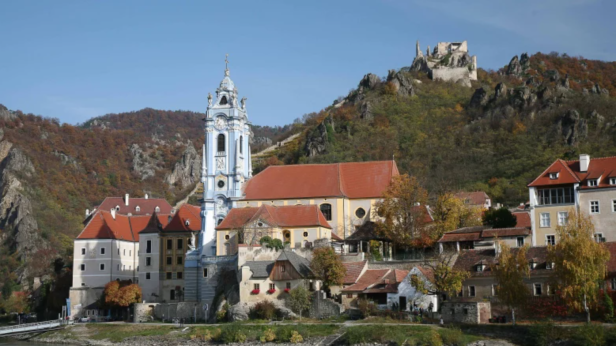 Dürnstein in der Wachau mit der Stiftskirche und der Burgruine im Hintergrund.