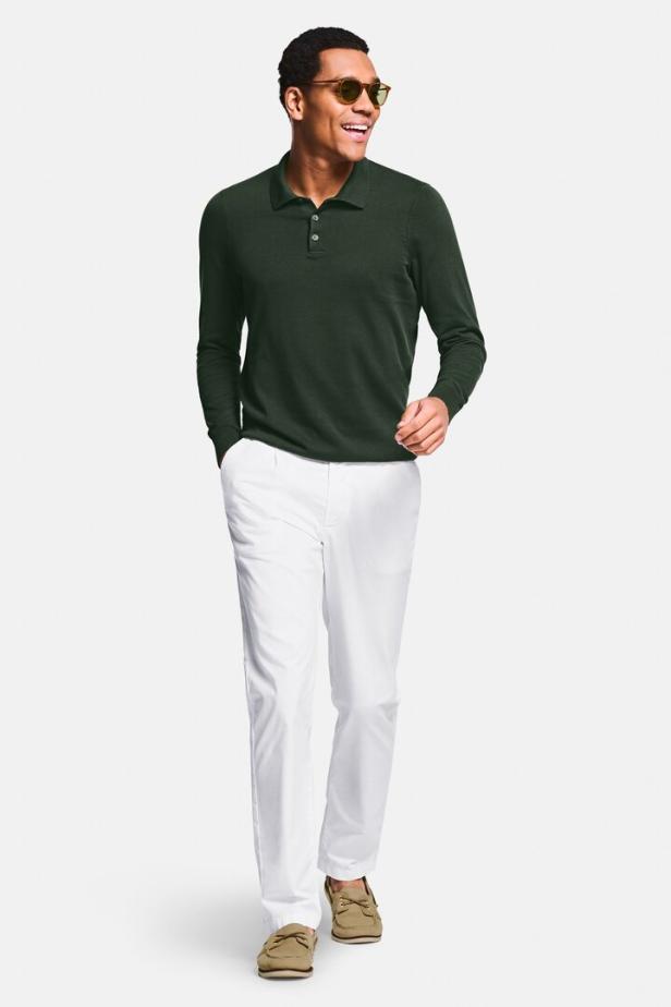 Ein Mann mit Sonnenbrille trägt ein grünes Polohemd und weiße Hosen.