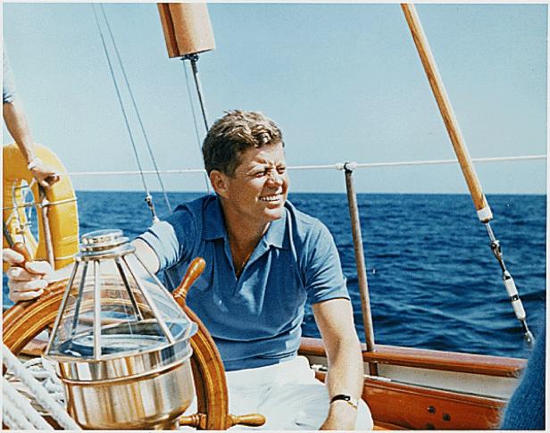 John F. Kennedy steuert ein Segelboot auf dem offenen Meer.