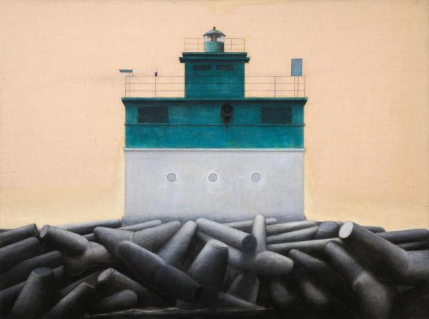 Ein grüner und weißer Leuchtturm steht auf einem Fundament aus Betonblöcken.
